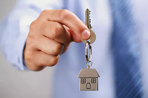 A title agent handing keys to a buyer